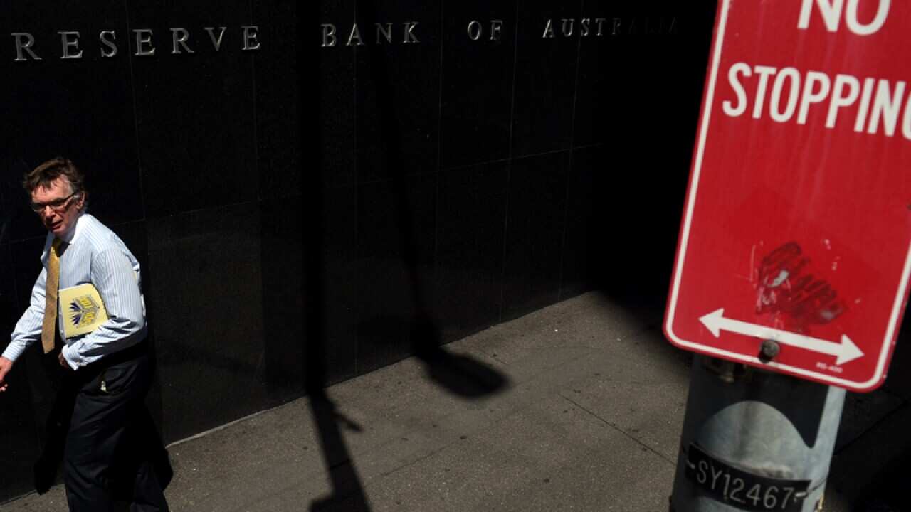 A pedestrian passes the Reserve Bank of Australia 's building, Sydney
