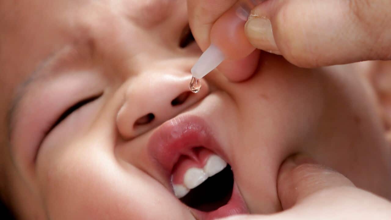 Health worker delivers a vaccine to a baby, east of Manila