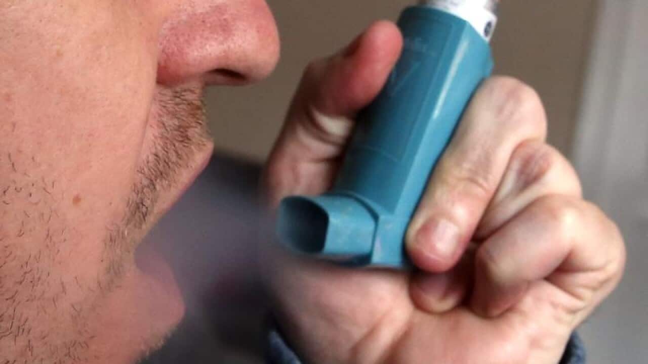 A man using an inhaler.