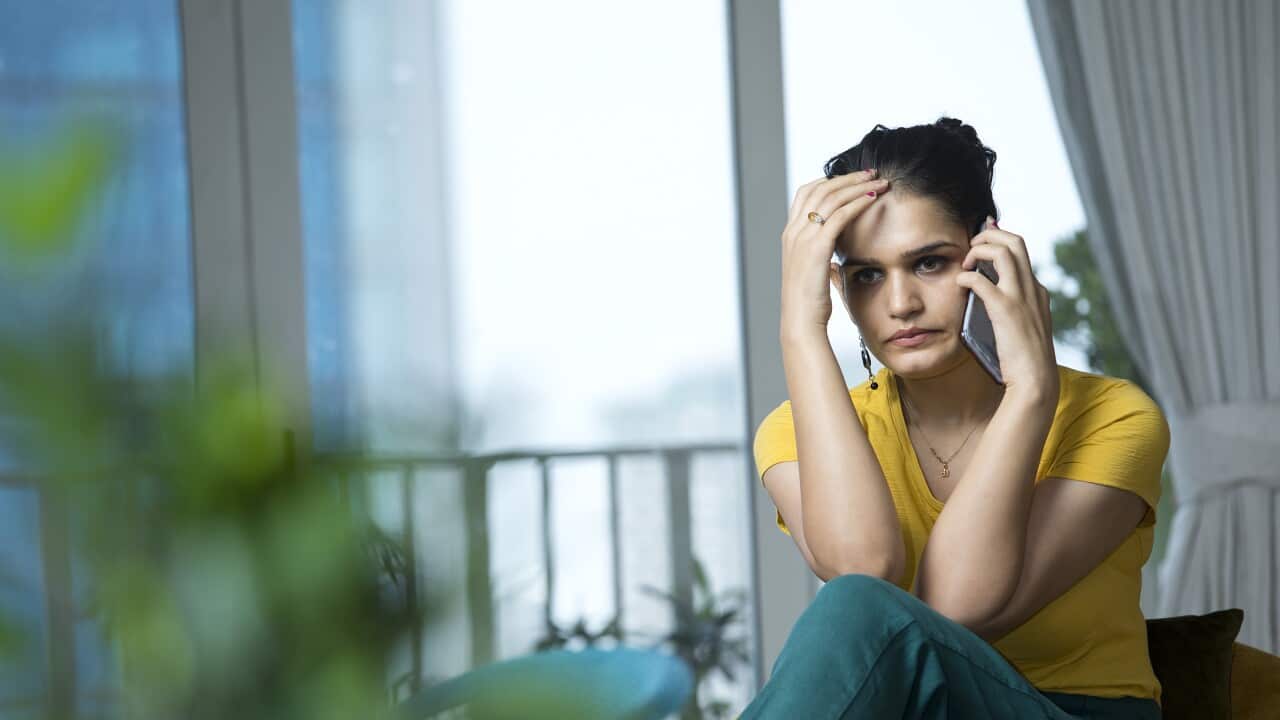 Sad woman talking on mobile phone