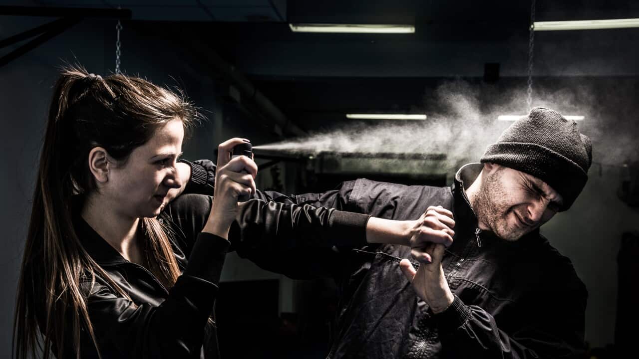 Woman using pepper spray for self defense against attacker