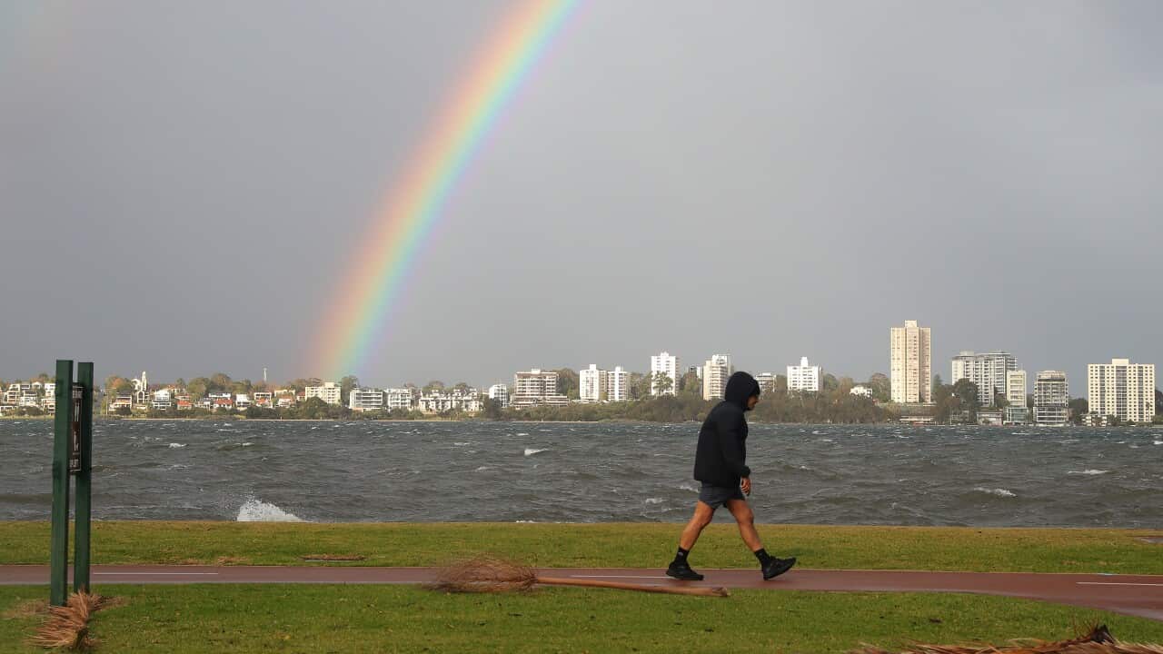A member of the public walks along the Swan river foreshore on Riverside Drive in Perth CBD which is partially closed due to storm flooding on Monday, May 25, 2020.
