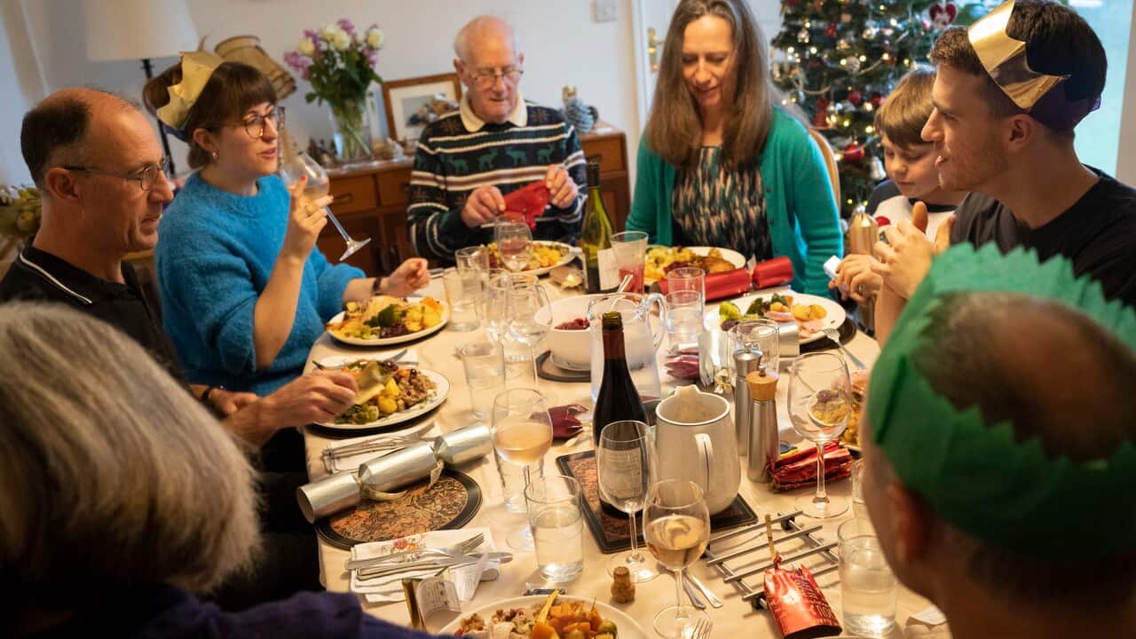 Family members sit down to eat a large Christmas Day lunch