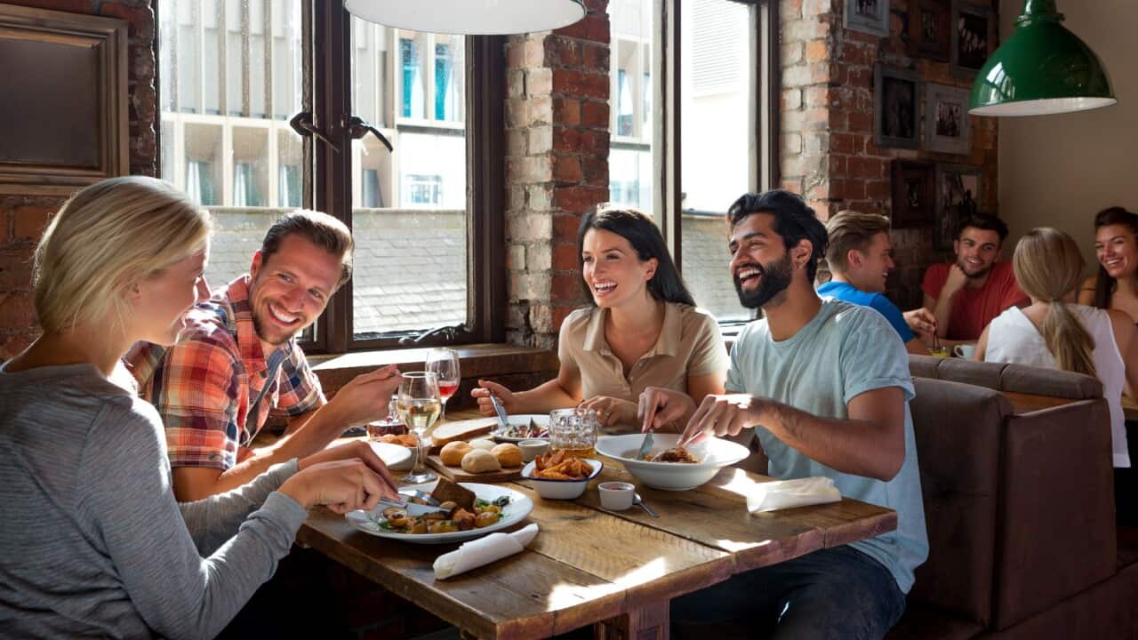 Group of friends enjoying a meal in a pub.