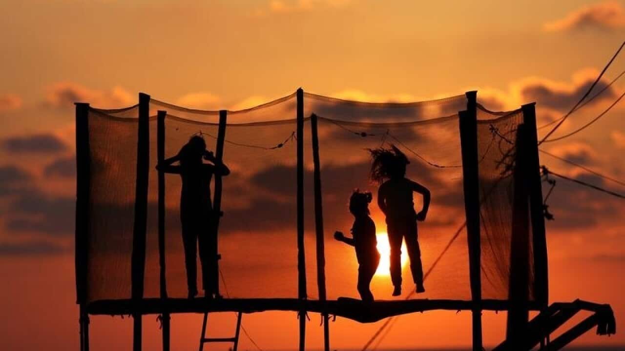 Children play on a trampoline.