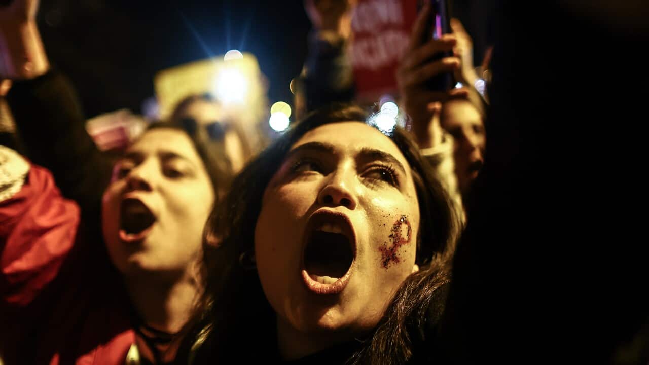 Close up two women with their mouths wide open at a women's rights protest.