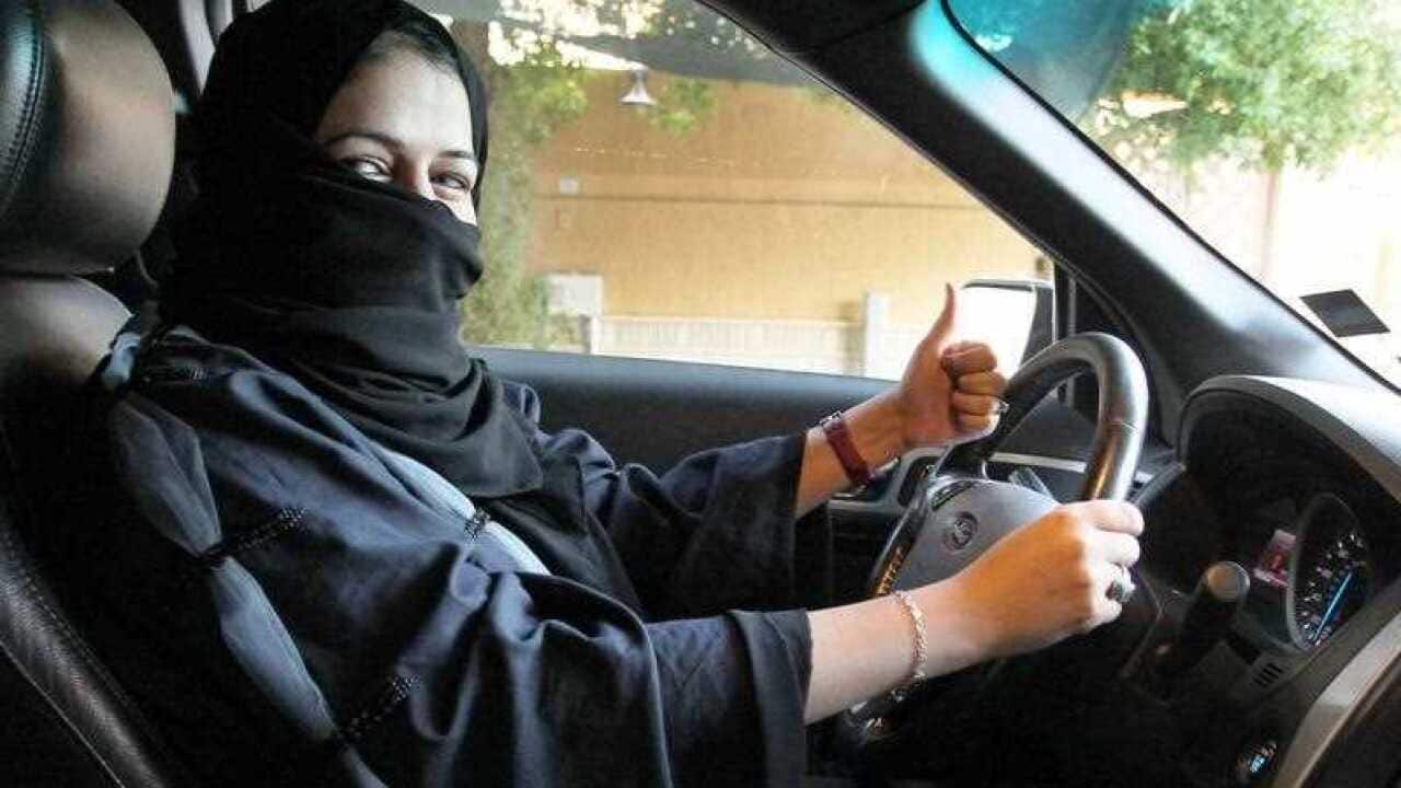 A woman gives a thumb up as she sits behind the wheel of a car in Riyadh, Saudi Arabia