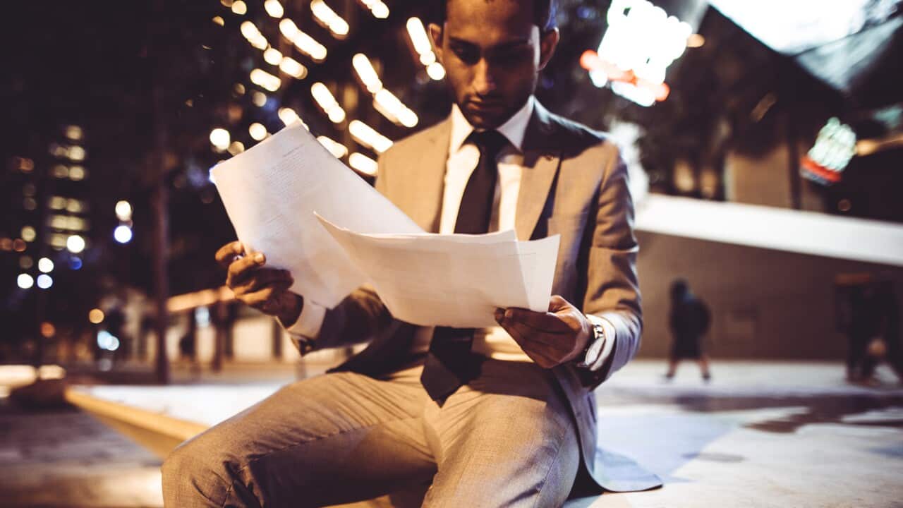 businessman on reading paperwork at night in the city
