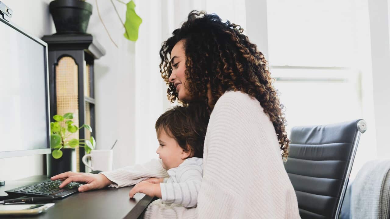 Mom uses computer while telecommuting
