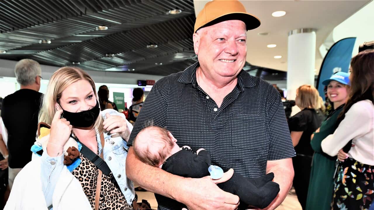 Col holds his grandson Ted for the first time after greeting him and mother Lauren from an early morning the first flight from Melbourne to Brisbane.