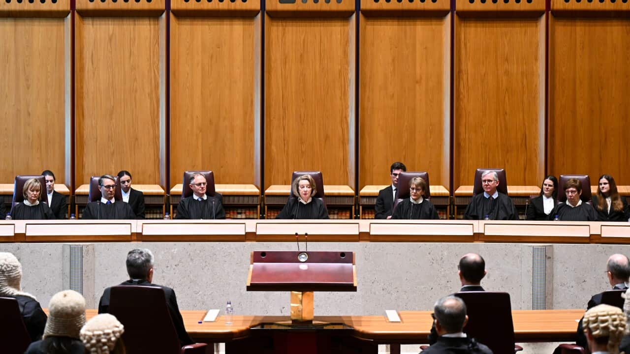 A panel of judges is seated on elevated chairs in the high court, overseeing proceedings.