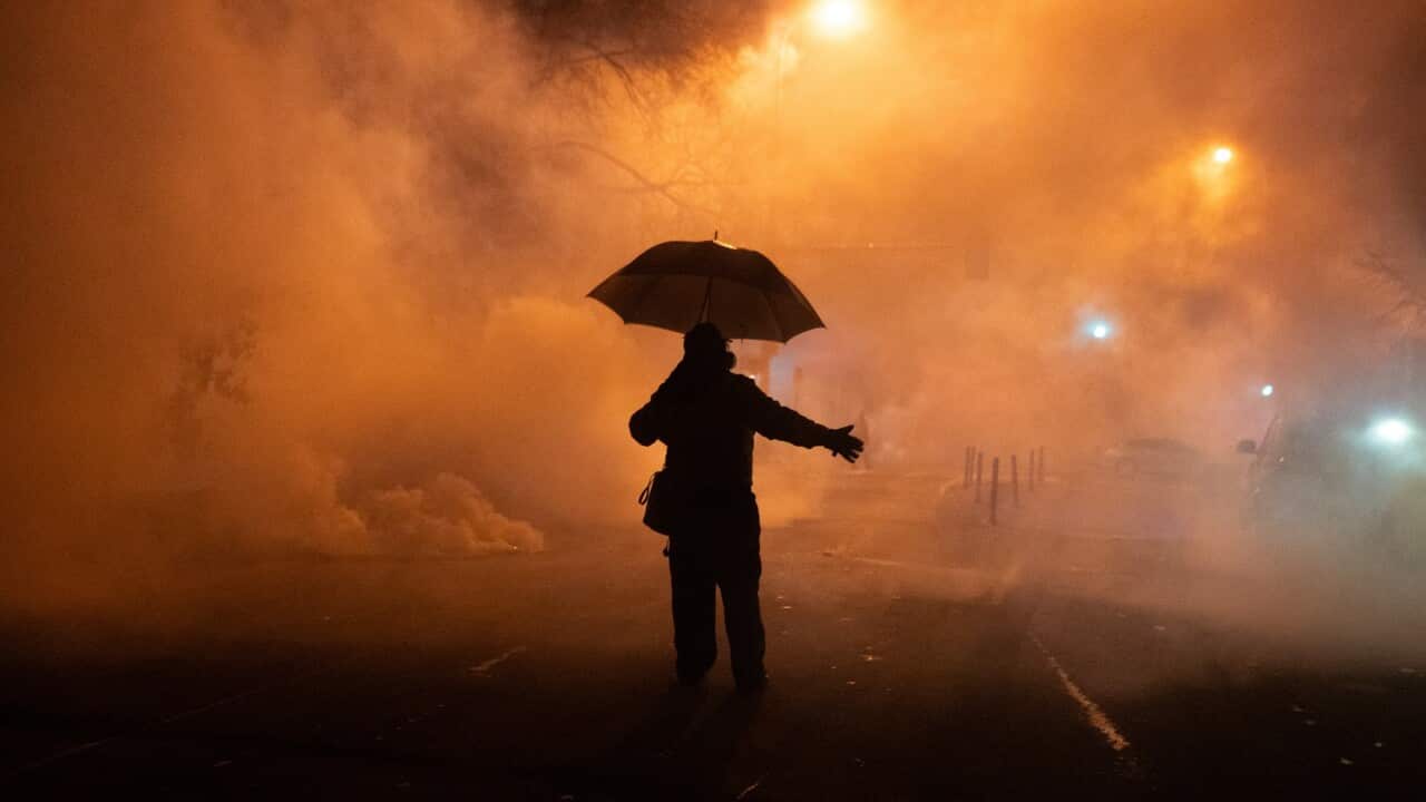 A person walks through a cloud of tear gas deployed by federal agents at a protest in Minneapolis (AAP)