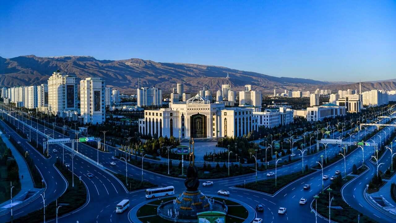 City buildings with mountains in the background.