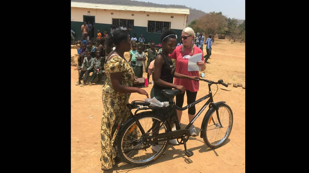 Dagmar Geiger presents a bike to schoolgirl in Zambia.