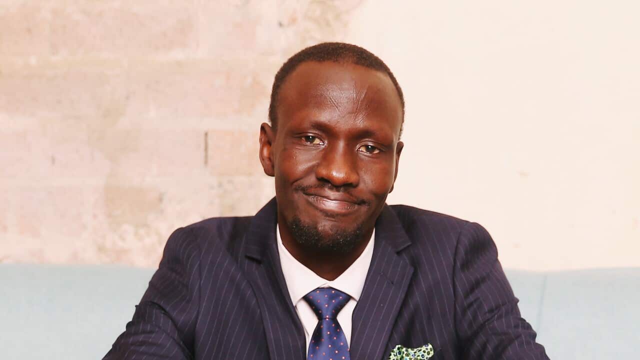 Deng Adut sitting on a couch