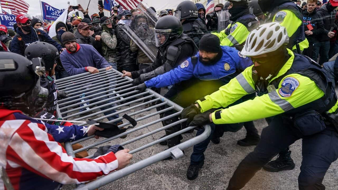 Trump supporters try to break through a police barrier