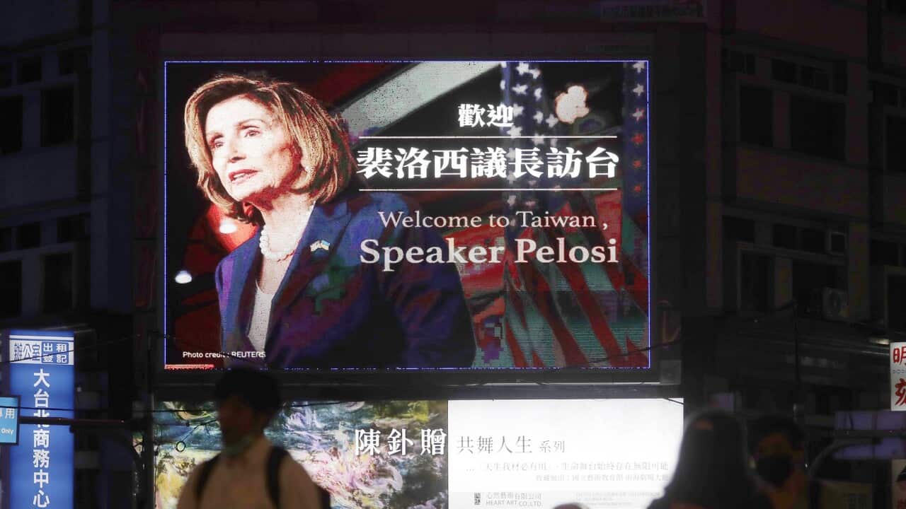 People walk past a billboard welcoming Nancy Pelosi, in Taipei, Taiwan