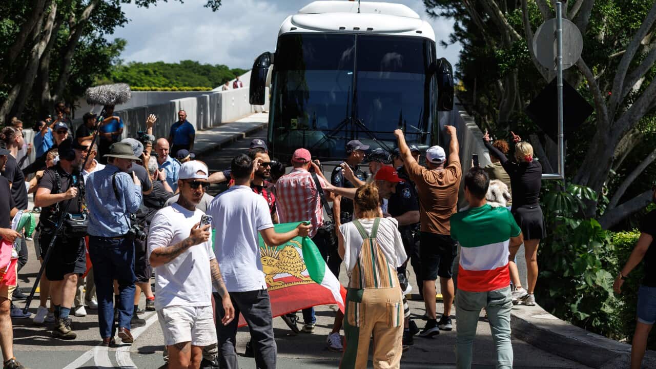 Protesters surround bus carrying members of Iran's women's football team as it leaves Gold Coast hotel for Sydney airport