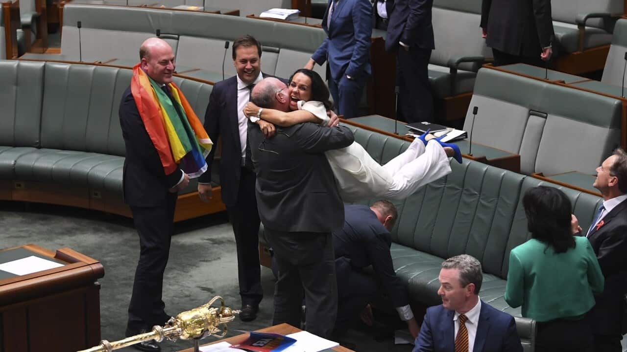 Liberal MP Warren Entsch lifts up Labor MP Linda Burney as they celebrate the passing of the Marriage Amendment Bill in the House of Representatives at Parliament House in Canberra, Thursday, December 7, 2017. (AAP Image/Lukas Coch) NO ARCHIVING