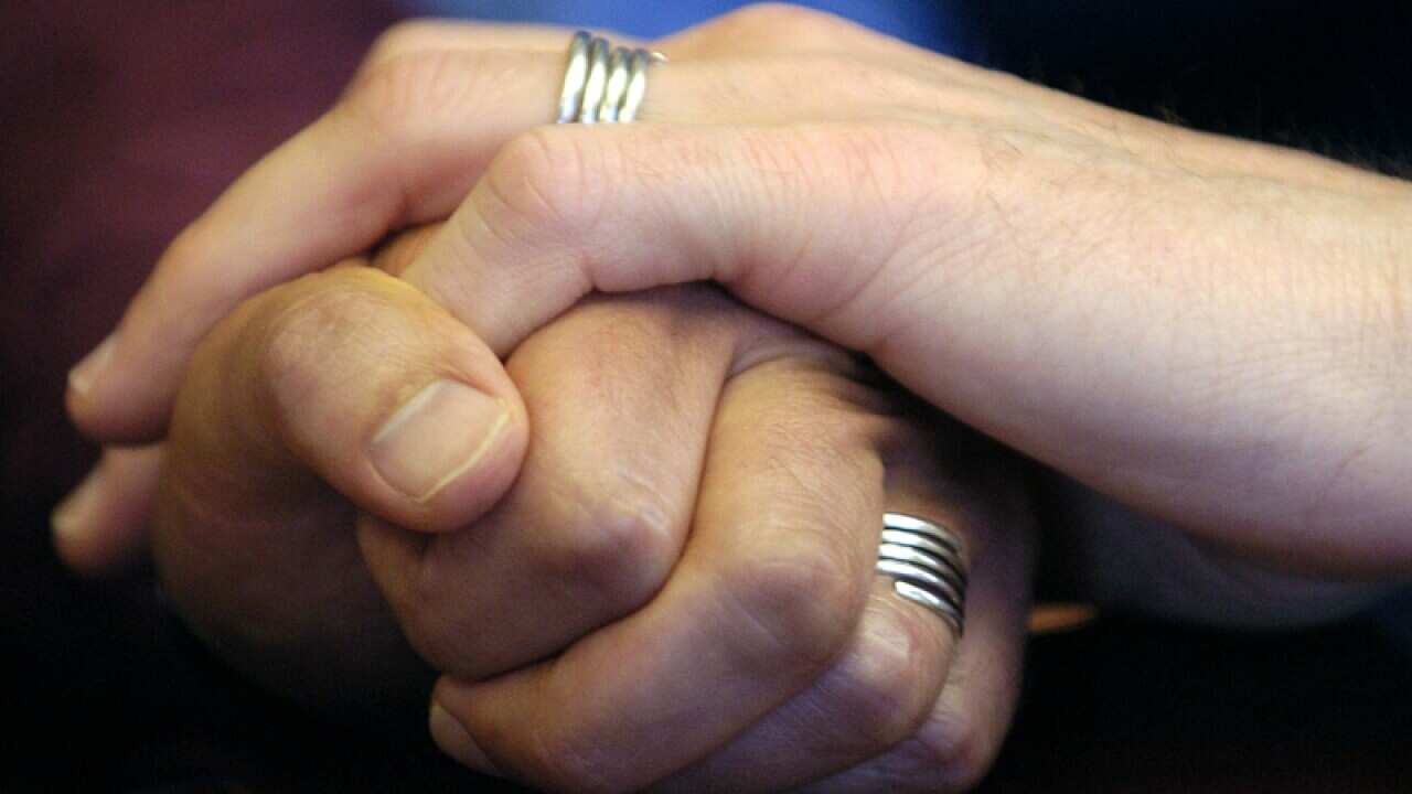 A couple displays their wedding bands
