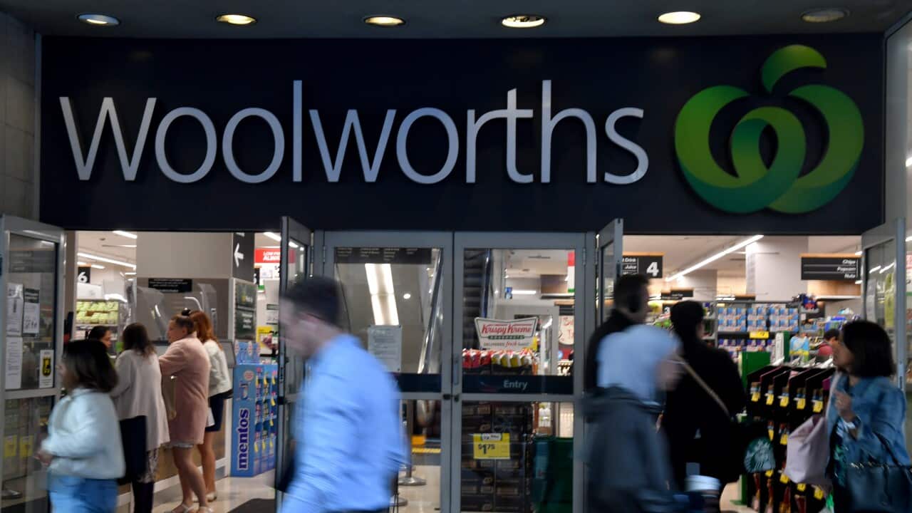 People walking past, and into, a Woolworths store.
