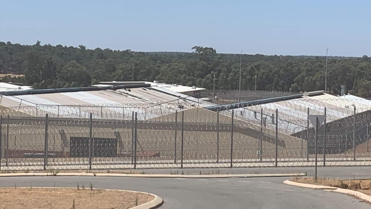 The aftermath of Sunday's riot at Acacia Prison shows a damaged roof in the distance where some inmates were.