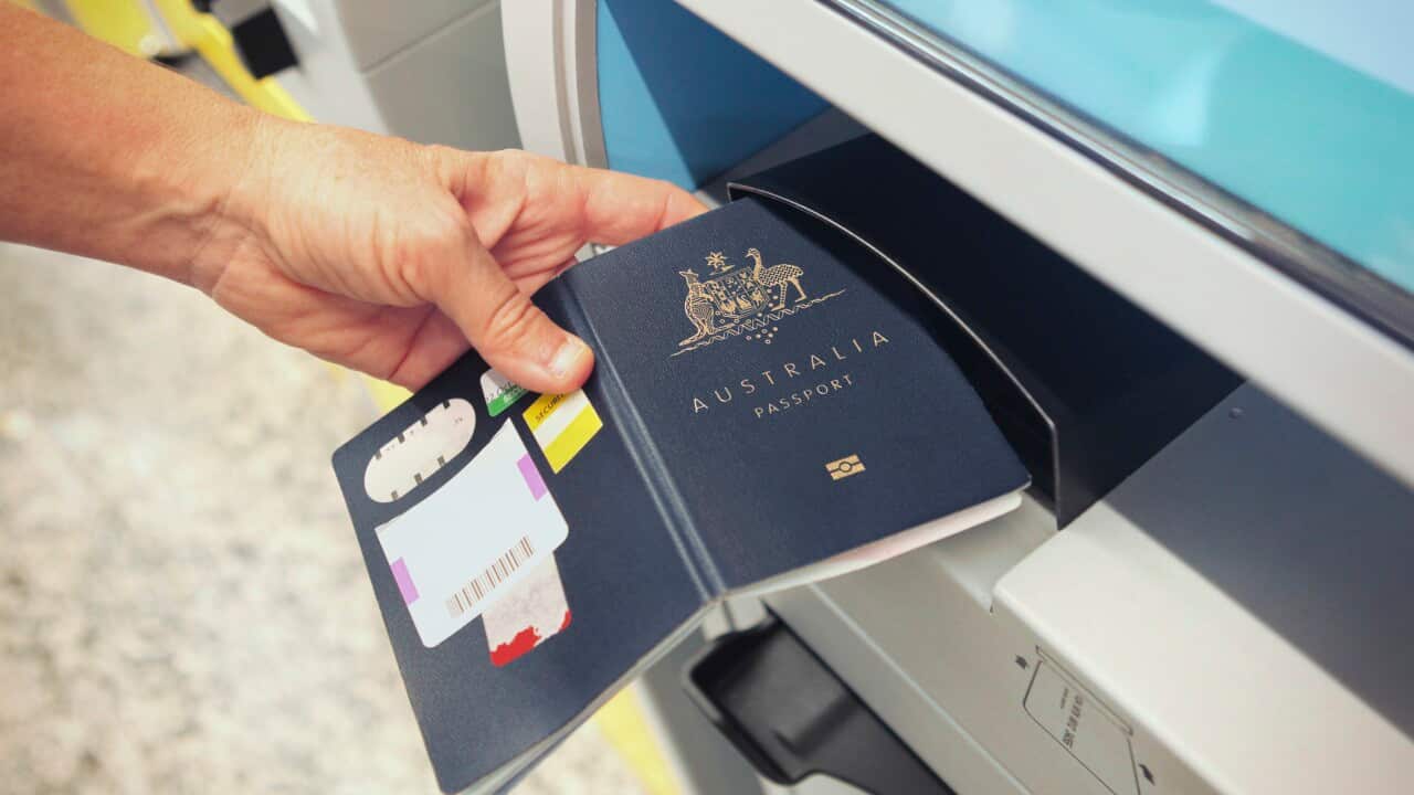 Someone scanning an Australian passport at a check-in counter.
