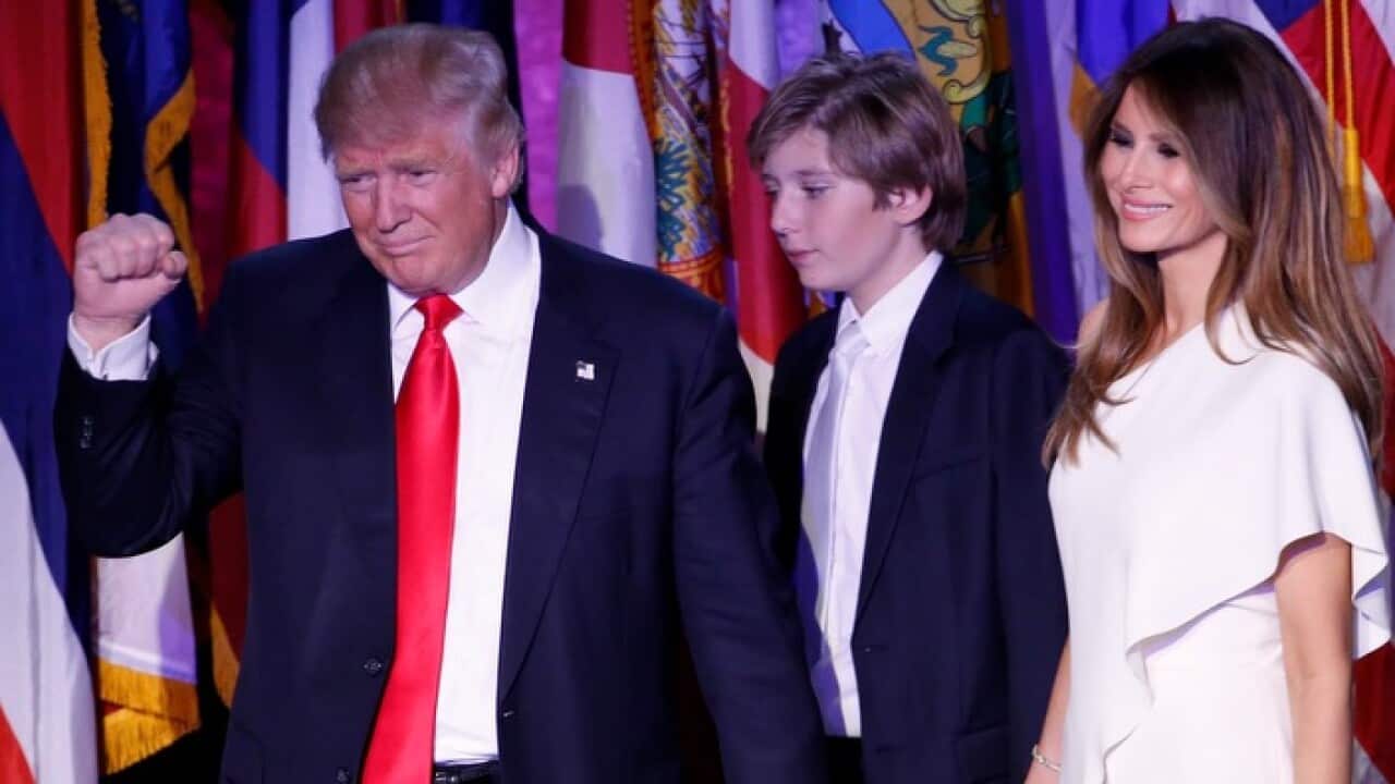 epaselect epa05623721 US Republican presidential nominee Donald Trump (L) gestures next to his son Barron (C) and his wife Melania Trump (R) as he delivers a speech on stage at Donald Trump's 2016 US presidential Election Night event as votes continue to