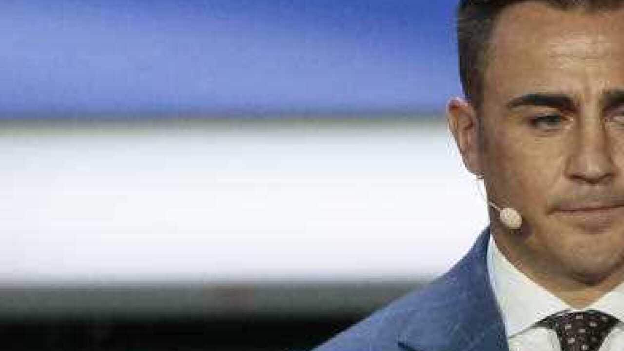 : Fabio Cannavaro holds up the team name of Australia at the 2018 soccer World Cup draw (APP)