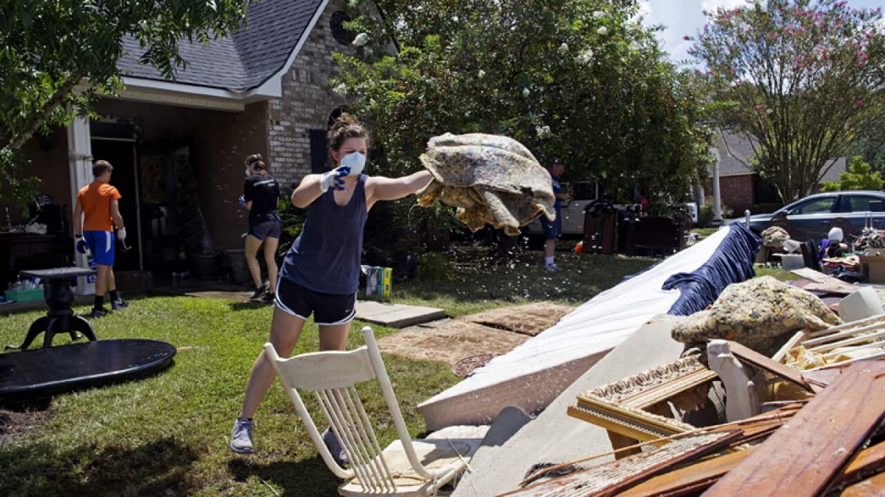 Volunteers help throw out waterlogged items from a home in Baton Rouge