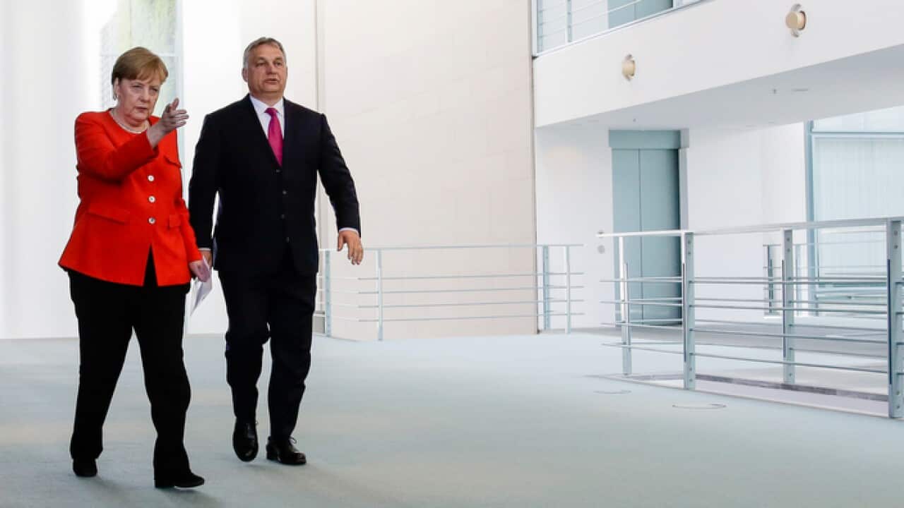 German Chancellor Angela Merkel, left, and Hungarian Prime Minister Viktor Orban, right, arrive for a news conference after a meeting at the chancellery in Berlin, Thursday, July 5, 2018. (AP Photo/Markus Schreiber)