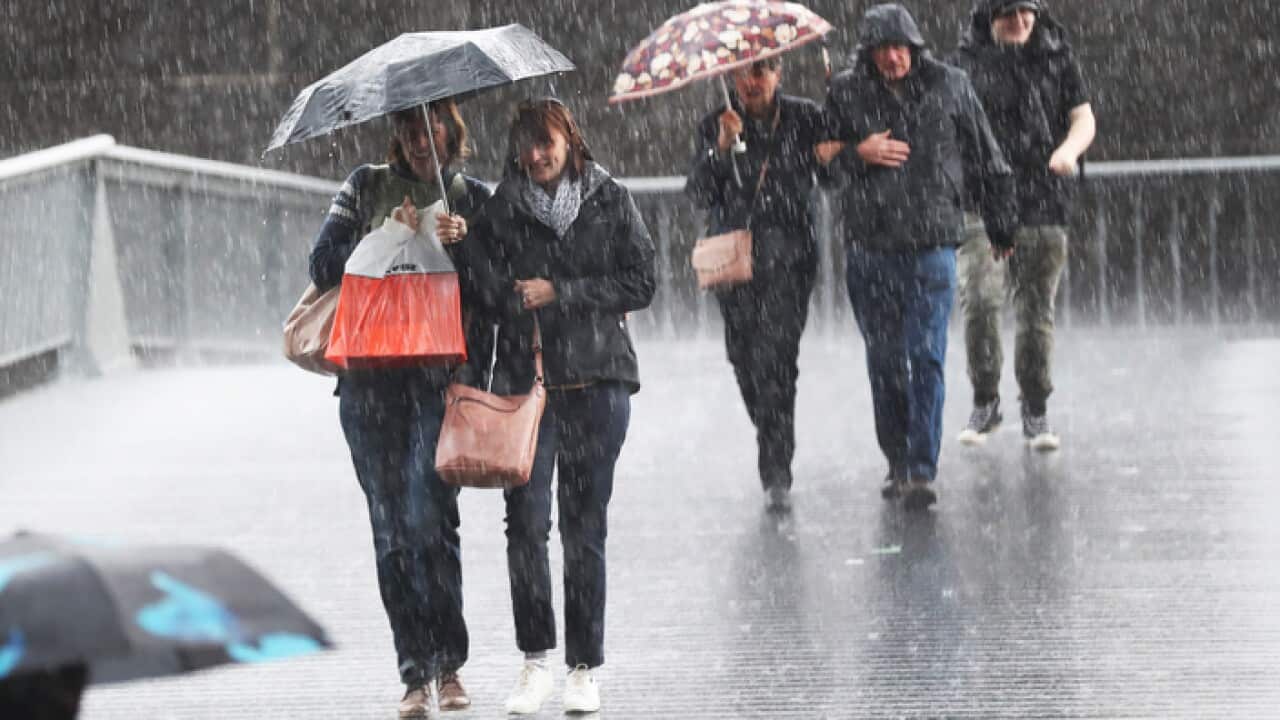 Pedestrians are seen in the rain on Southbank in Melbourne, Friday, May 10, 2019. The forecast rainfall is part of a vigorous cold front that will deliver rain to much of Victoria. (AAP Image/David Crosling) NO ARCHIVING