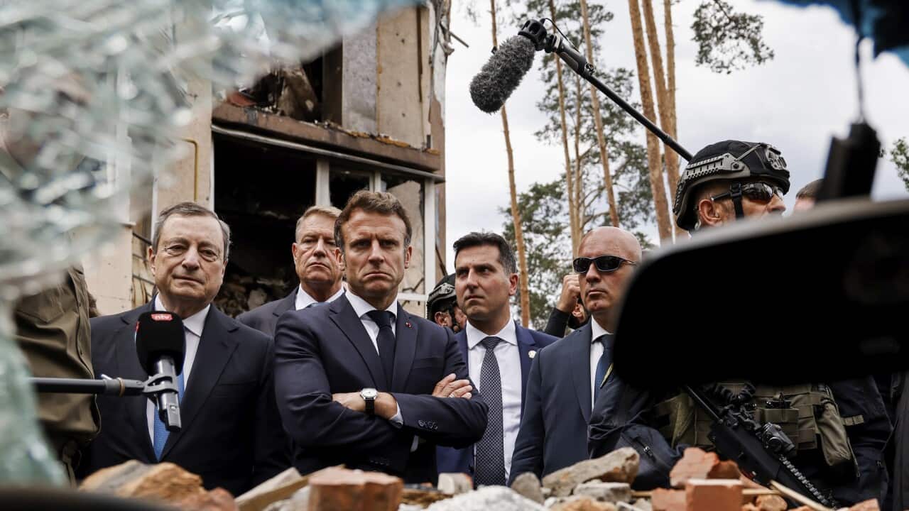 Italian Prime Minister Mario Draghi, left, and French President Emmanuel Macron watch debris as they visit Irpin, outside Kyiv.