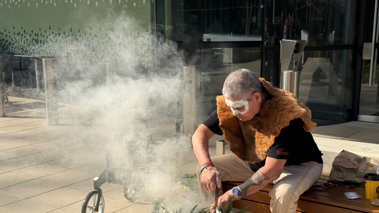 a man conducts a smoking ceremony outside a courthouse