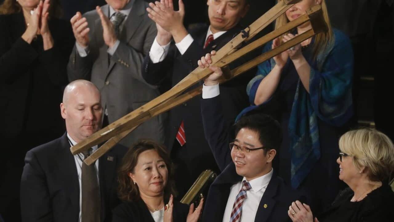 Ji Seong-ho raises his crutches at the US State of the Union address (AAP)