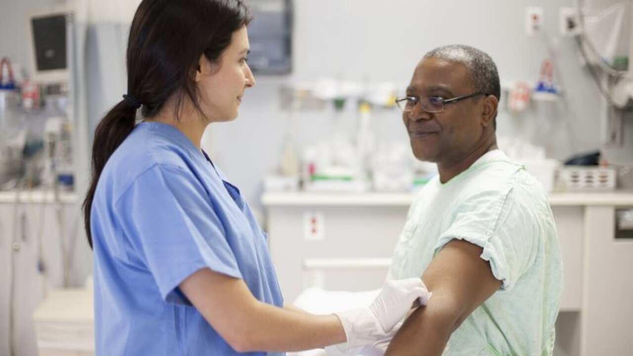 Nurse taking blood from patient in hospital
