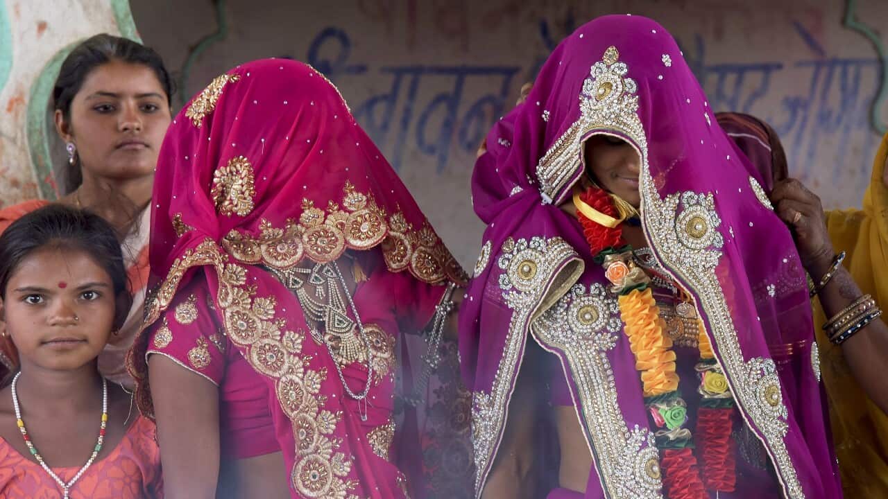 An underaged bride, right, stands with family members during her marriage at a Hindu temple near Rajgarh, Madhya Pradesh state, India.