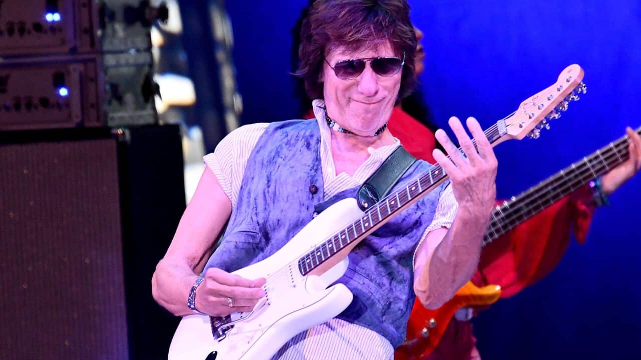 Man plays an electric guitar on a stage.