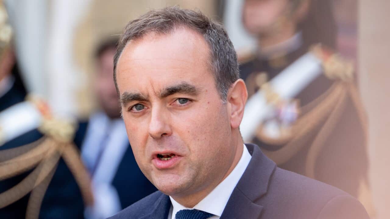 Sébastien Lecornu speaks in front of a microphone with a blurred background