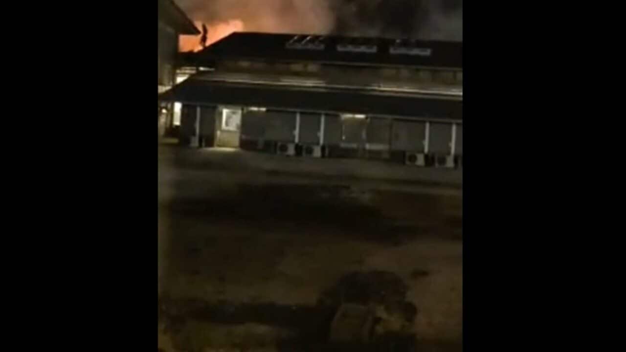 Video on social media shows a building on fire at Christmas Island Detention Centre, and a detainee on the roof.