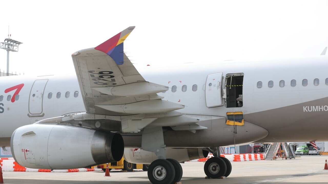 An Asiana Airlines plane on the tarmac with an emergency exit door open