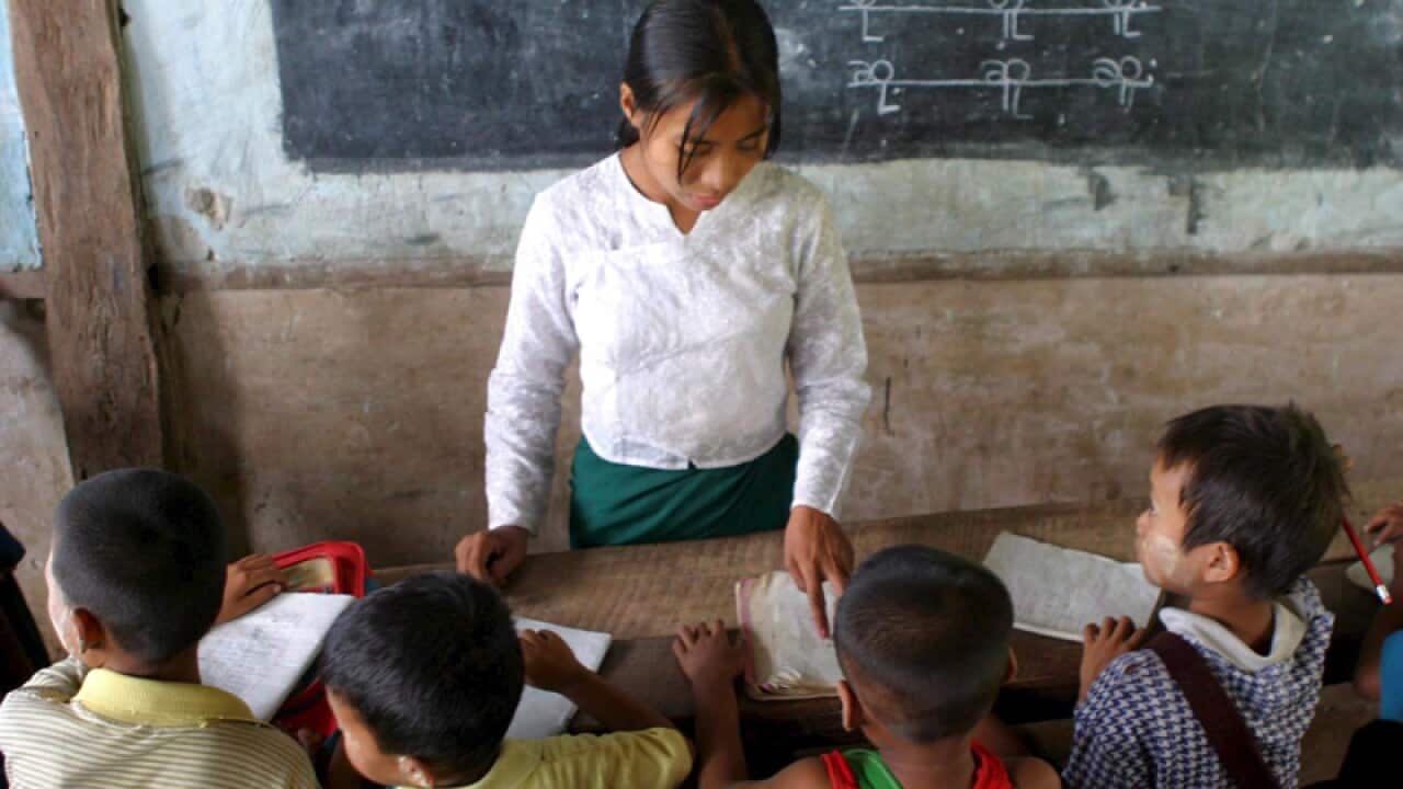 School children learn Burmese with their teacher in Myanmar