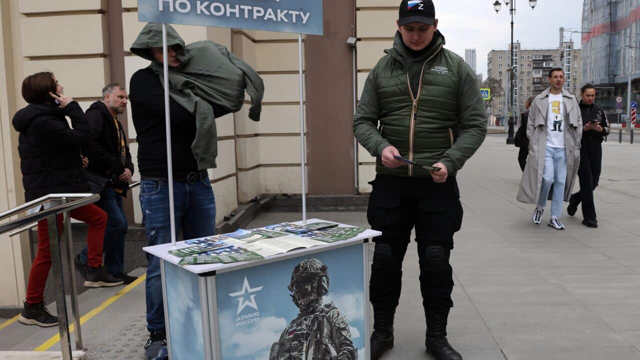 A man holds promotional materials of Russian Defence Ministry, campaigning to sign up for contract service