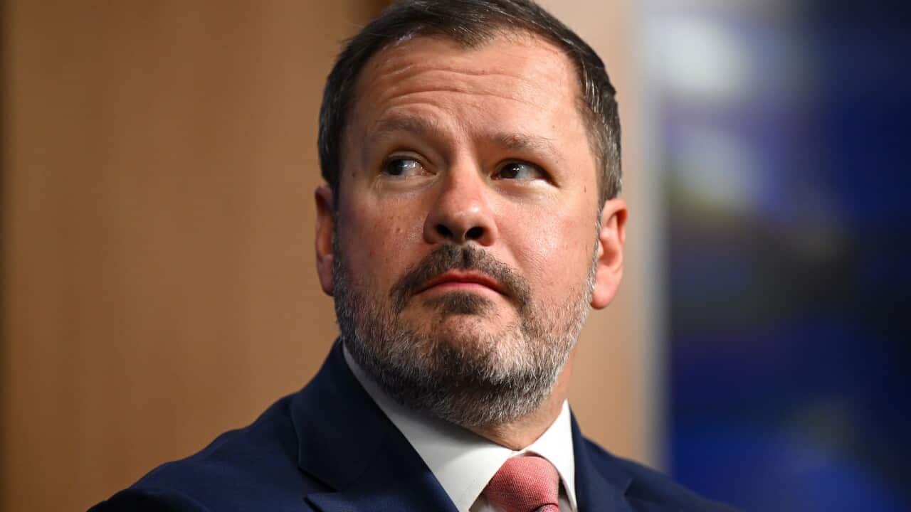 Ed Husic looks over his right shoulder