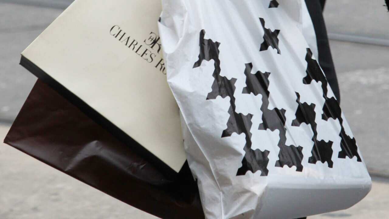 A shopper carries shopping bags