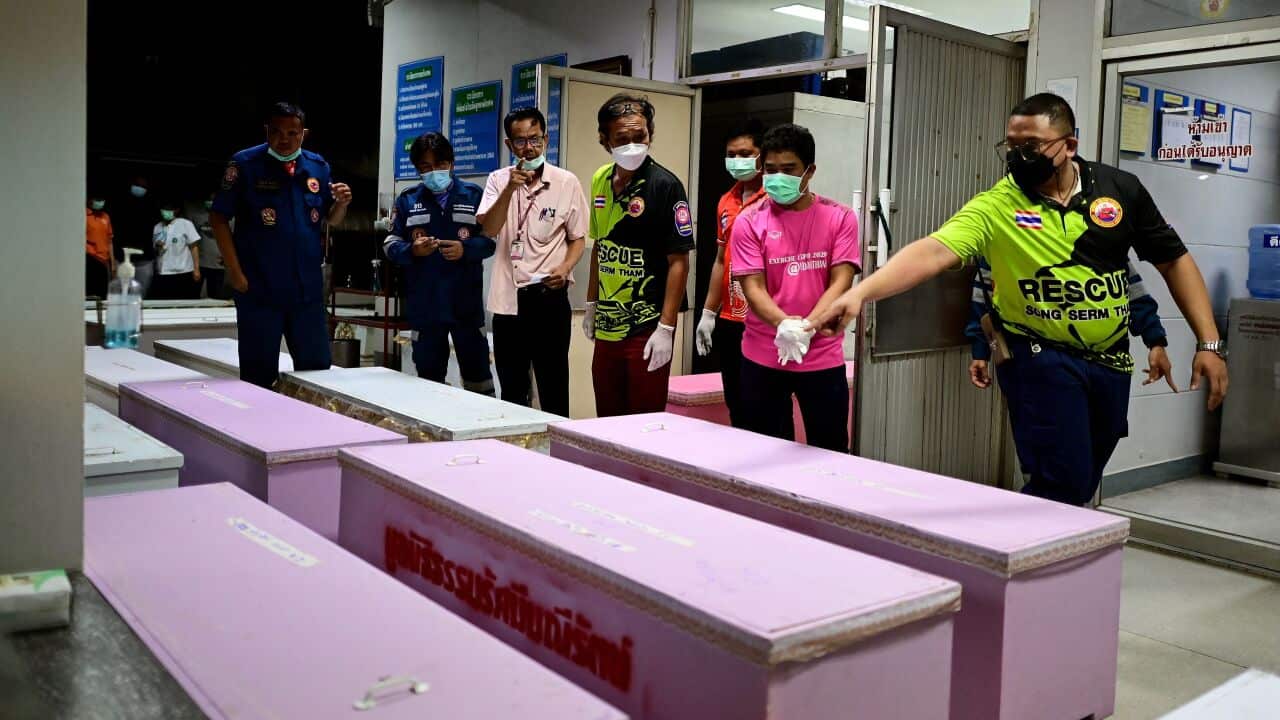 Rescue personnel count coffins carrying victims bodies at the hospital morgue in Udon Thani following a mass shooting