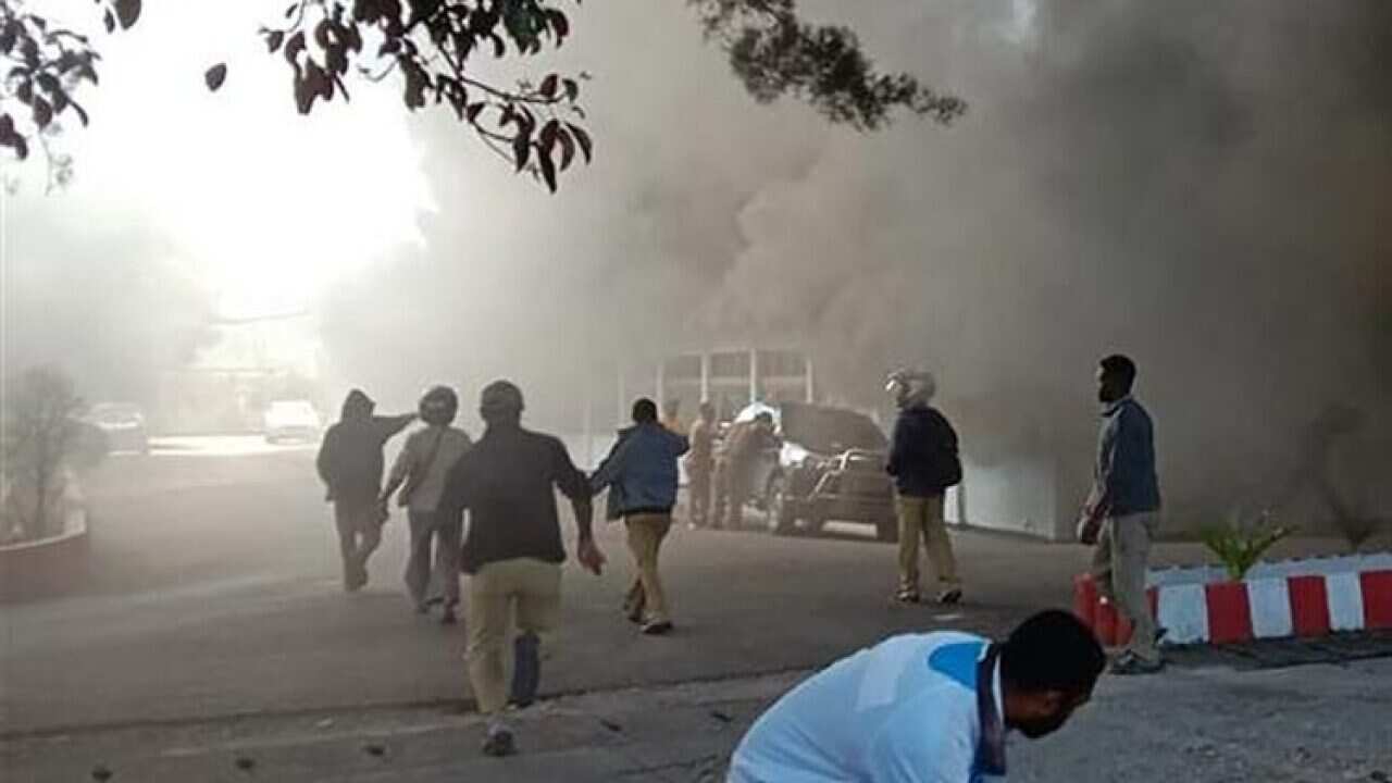 People react as a building burns after fresh protests broke out in Wamena on September 23, 2019.