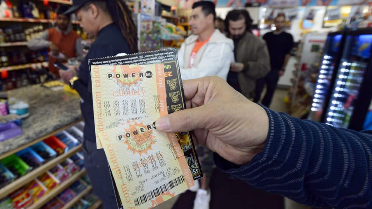 A customer holds up a Powerball lottery ticket in Canoga Park