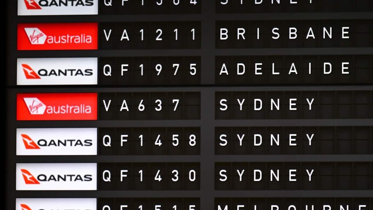 Departing flights are seen displayed on an Airport flight departure board at Canberra Airport in Canberra.