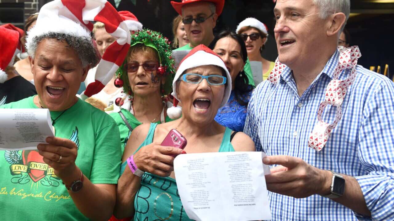 PM Malcolm Turnbull (right) sings with a choir at Wayside Chapel
